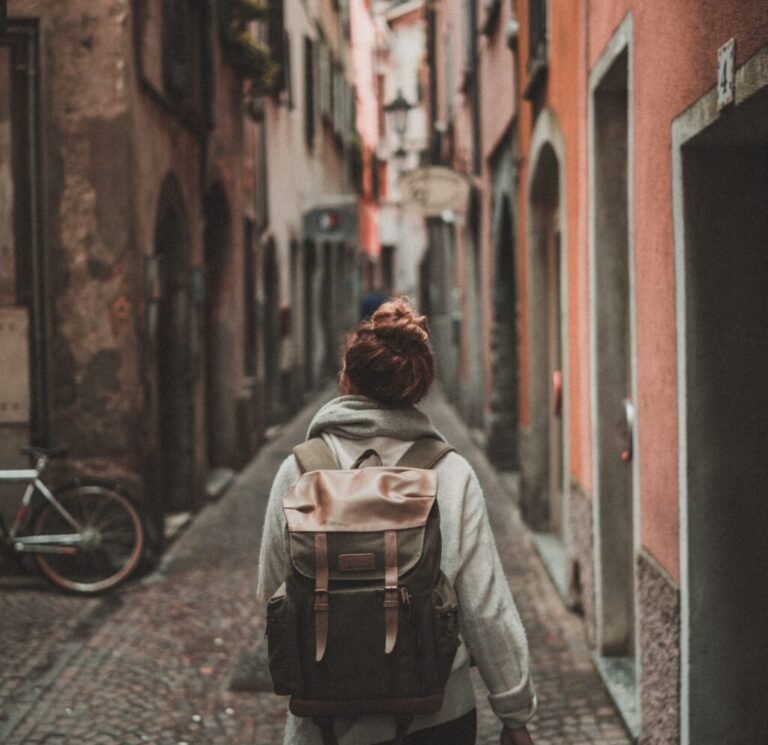Traveller with a backpack exploring an old town street while travelling abroad